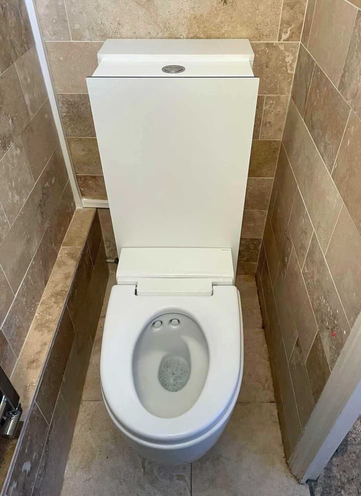 Geberit AquaClean Mera Care wash and dry toilet installed in a private bathroom Geberit AquaClean Mera Care wash and dry toilet installed in a private bathroom