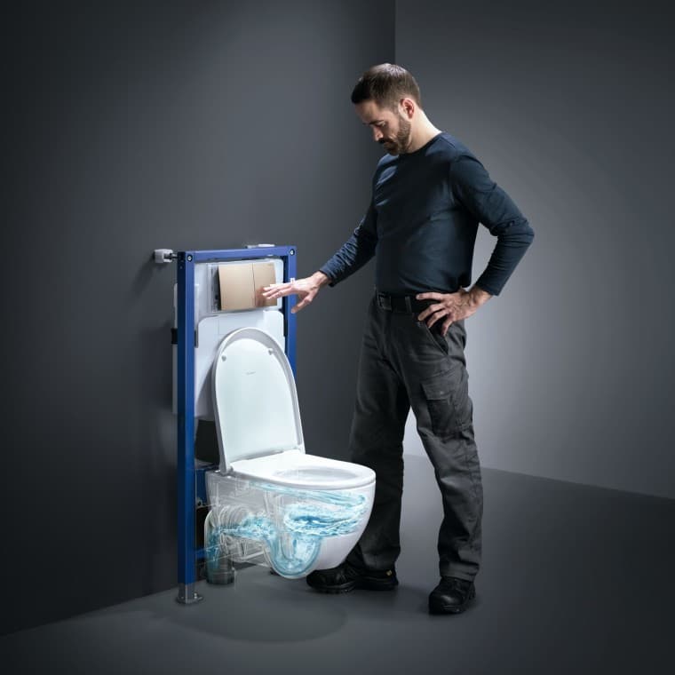 Man actuates the TurboFlush technology of a Geberit Acanto toilet Man actuates the TurboFlush technology of a Geberit Acanto toilet
